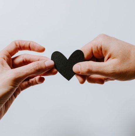 hands holding black paper heart